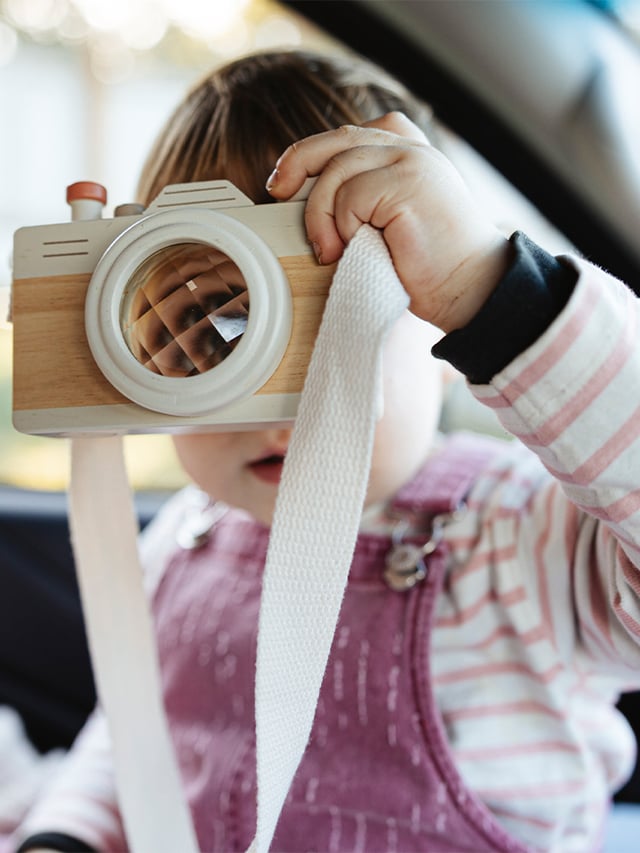 Little girl holding up her toy camera